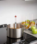 Classic Line Candy And Deep Fry Thermometer with blue spirit in pot on stovetop near caramel apples