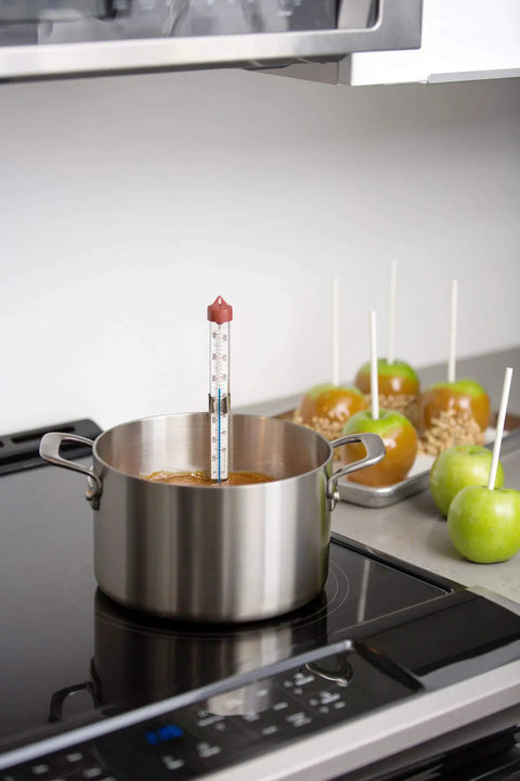 Classic Line Candy And Deep Fry Thermometer with blue spirit in pot on stovetop near caramel apples