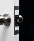 Close-up of Heavy Duty Outswing Door Latch Guard Cover Kickproof Black Steel Striker Plate for Deadbolt security on a door.