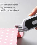 Ultra Slick Cordless Electric Scissors For Fabric Cutting And Crafting Projects delivering comfortable grip for easy cutting on pink fabric.