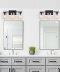 Matte Black Four Light Vanity Fixture With Clear Glass Shades above bathroom mirrors