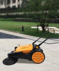 Workhorse Walk Behind Outdoor Sweeper, No Fuss Hand Push Pavement Cleaner With Generous Debris Hopper on paved surface.