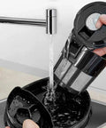 Hassle Free Mini Coffee Maker With Built In Bean Grinder And Glass Carafe, Solid Six Cup Drip Brewer being rinsed under faucet.