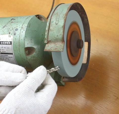 Using Heavy Duty Seven Inch Bench Grinding Wheel 100 Grit Chrome Corundum to sharpen metal drill bit on grinder.
