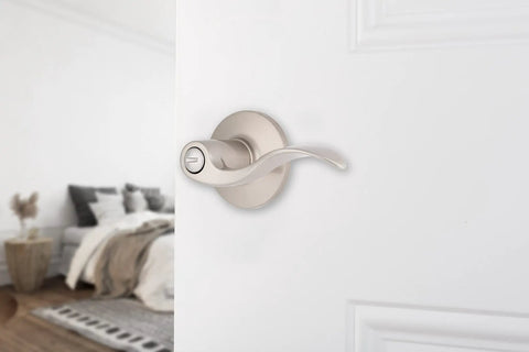 Six Pack Satin Nickel Privacy Locking Wave Door Levers For Interior Doors on white door, transitional bed bath setup visible