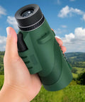 Hand holding an HD Monocular Telescope With 42mm Objective Lens, High Powered Spotting Scope, green rubber grip, outdoors