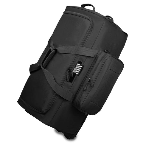 Rolling duffle bag, black 120L, side-angle view with wheels, carrying strap, and multiple zip pockets.