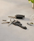 Ultra Slim Metal Multi Tool Card With Bottle Opener And Hex Wrench For Wallet Or Keychain on a keyring with keys and bottle cap.