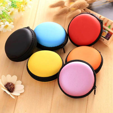 Portable Round Zippered Tech Case For Earphones USB Cables And Hard Drive Hella Durable Eva Shell in assorted colors on wooden background.