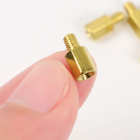 Hardcore Heavy Duty M3 Hex Brass Standoff Spacers 10 Piece Set Male Female Threaded Screws in hand, showcasing precision details.