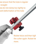 Brake line flaring tool with red clamp and black knob gripping a silver metal tube, hand holding tube