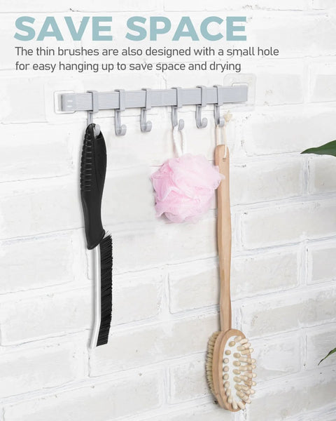 Side view of crevice cleaning brush and grout scrub brush on a gray wall-mounted hook rack with a pink loofah