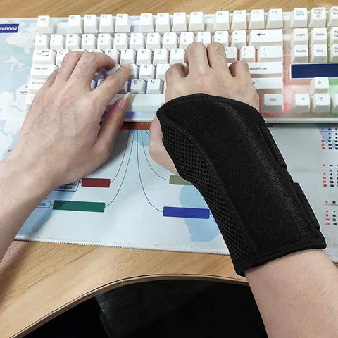 Person typing on keyboard wearing Wrist Brace For Carpal Tunnel Relief Right Or Left Hand With Night Wrist Sleep Support Adjustable Straps