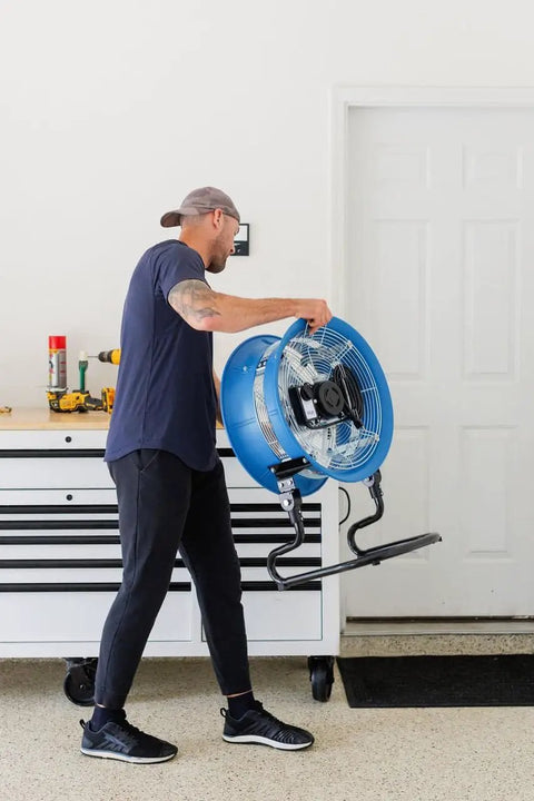 Person carrying a Powerful 18-Inch High-Velocity Heavy-Duty Industrial-Grade Floor Fan with 3 Speeds and 3-Position Tilt for Reliable Cooling