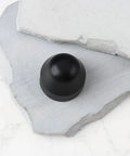 Black rubber 4Pcs Dope E Bike Wheel Nut Cap 21mm inner diameter on white stone surface.