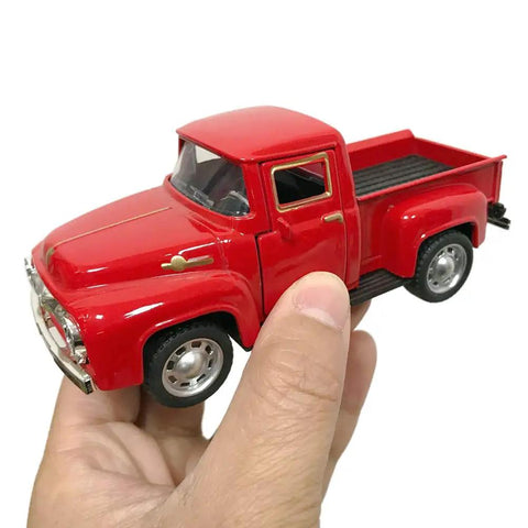Hand holding Red Metal Truck Christmas Decor For Farmhouse Style Vintage Pickup Truck Tabletop Storage Die Cast Metal With Hand Painted Finish Perfect Holiday Gift For Car Folks And Decor Enthusiasts.
