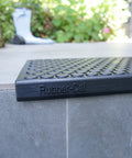 Close-up of Coin Grip Grippy Non Slip Rubber Tread Stair Mats 6 Pack Black on outdoor steps, featuring coin pattern and Rubber-Cal branding.