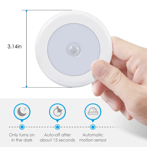 Hand holding a 3.15 inch Upgraded Motion Sensor LED Light Stick On Battery Powered Night Light with auto-on feature in white.
