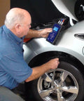 Technician using EV Motor Tester Deenergized Circuit Analysis Diagnostics on a silver hybrid car tire.