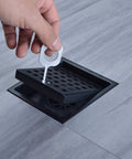 Installing Matte Black 4 And A Quarter Inch Round Shower Drain Grate With Adjustable Threaded Base Flange Built To Last Fits Two Or Three Inch Drain Pipes Stainless Steel Grate ABS Flange Heavy Duty Construction on bathroom tile.