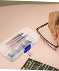 Close-up of eyeglass repair kit with screws, screwdriver, and tweezers, demonstrating use for quick fixes and DIY repairs.
