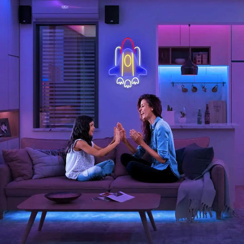 Rad Neon Rocket Sign LED Light For Bedroom Decor illuminating a cozy living room with a cosmic universe glow above a sofa