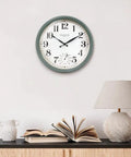 Cool Outdoor And Indoor Weather Station Clock With Thermometer Fahrenheit And Celsius Analog Two In One Wall Decor In Aged Teal Finish 13 Inch Perfect For Patio Porch Garden Kitchen Or Office Wall Mount displayed indoors above a table with books and a lamp.