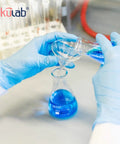 Hands pouring liquid into Sturdy Borosilicate 3 3 Glass Conical Flask Set With Printed Graduation 50 Milliliters Each Six Pack Great For Lab Experiments Tough As Nails Built Heat And Chemical Resistant