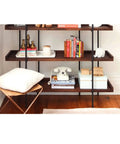 Built Different Heavy Duty Black Iron Bookshelf With Real Wood Shelves Industrial Floor Standing Storage Rack For Living Room Setup Home Office Display Organizer showcasing books, decor, and a phone on shelves.