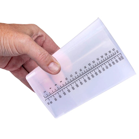 Hand holding 32 Oz Graduated Triangular Intake Output Containers, Plastic, 5 Pack For Precise Urine Output And Lab Measurements, Clear Beakers With Oz And CC Markings, Durable Bulk Pack with oz and cc scales