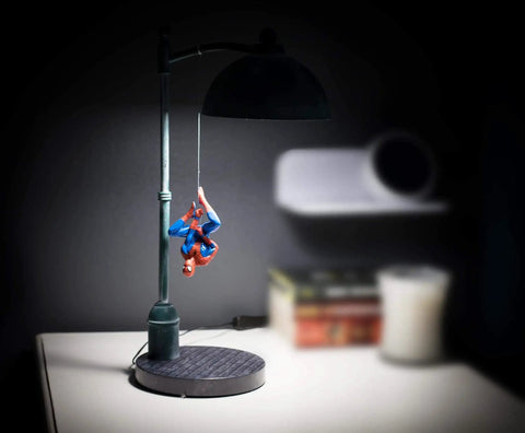 Spider Man Streetlight LED Mood Desk Lamp For Heroes Night Light 16 Inch Marvel Themed Desk Light With Bright LED Glow Lit Street Lamp Style For Fans And Collectors on a desk with Spider-Man figure hanging.