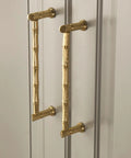 Gold Brass Bamboo Shape Cabinet Handles Set, Antique Brushed Copper Finish, installed on a cabinet with screw details visible