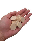 Hand holding multiple 1 inch smooth edge unfinished round wood slices from 60 Pack 1 Inch Natural Wood Slices Unfinished Round Wood Cookies Real Deal Smooth Edged Pro Gear DIY Crafting Supplies Mini Wooden Disks For Paint Room Decor Makeovers.