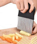 5-blade stainless steel vegetable cutter with black handle slicing carrot sticks on a wooden board