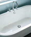 Copper Bath Tub Drain Stopper with Hair Strainer Basket installed in a modern bathtub with chrome faucet.