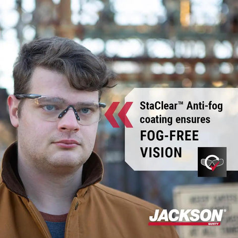 Top Tier Frameless Safety Glasses With Anti Fog Smoke Lenses And Scratch Resistant Coating For Super Comfy All Day Wear Plus Hella Tough Ansi High Impact Eye Protection For Men And Women In Sweet Value Packs Of Twelve worn by a man outdoors.