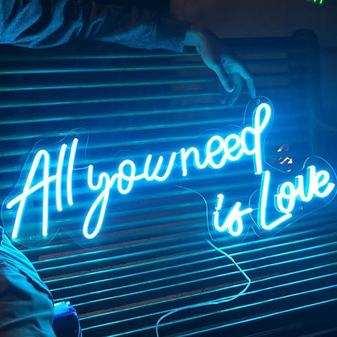 All You Need Is Love Neon Sign LED Light For Home Bar Party Decor, Customizable Neon Wall Art, 60x26cm displayed on a bench