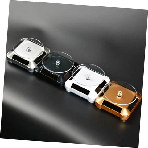Four sleek solar powered rotating jewelry display stands in silver, black, white, and gold, showcasing no batteries needed design.