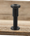Badass Stainless Steel Chicago Binding Screws M6 X 25 Millimeter with Secure Cap Nuts on wooden surface for crafts.