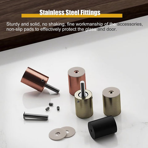 Stainless steel fittings with bronze, black, and gold finishes with screws and non-slip pads on a table.
