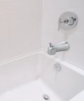 Tub Spout With Diverter In Chrome Finish, Durable Metal Construction installed in a white bathroom setting, universal fit for bathtubs.