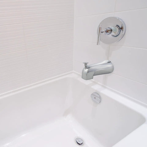 Tub Spout With Diverter In Chrome Finish, Durable Metal Construction installed in a white bathroom setting, universal fit for bathtubs.