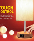 Round Fabric Shade Bedside Lamp With USB Ports And Touch Control 3 Way Dimmable Nightstand Light For Bedroom Living Room Dorm Or Home Office Corded Electric No Battery Fast Charge Phones And Tablets While You Sleep with hand using touch control on wooden base