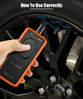 Tire Pressure Monitor System Relearn Tool El-50448 Orange Grip in use near valve stem on vehicle wheel.