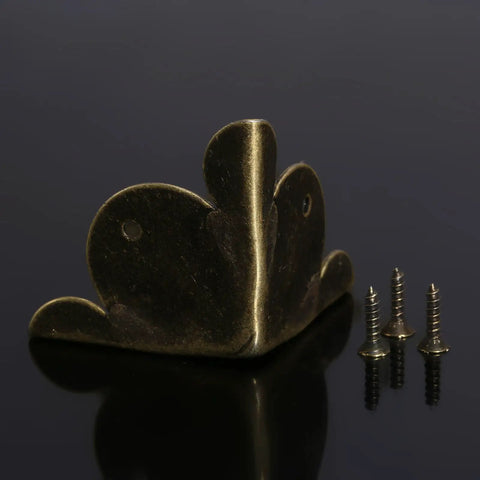 Solid Antique Bronze Corner Protectors, 12 Piece Heavy Duty Furniture Edge Guards with screws on black surface.