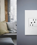 Adorne 15 Amp Tamper-Resistant Outlet With Matching Wall Plate, Gloss White, installed on grey wall, living room view, UL Listed
