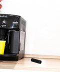 Black insulation sleeve for steam wand guard and rubber cover heat shield for coffee machines next to an espresso machine