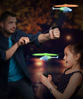 Adult and child launching Light Up Flying Helicopters Set Of 2 With LED Lights And Handheld Launcher in night setting