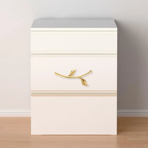 Gold bird-shaped ergonomic metal cabinet handle on white dresser, part of Ergonomic Metal Cabinet Handles And Drawer Pulls For Cabinets.