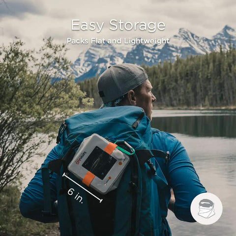 Backpacker with Two In One Solar Camping Lantern And Phone Charger on backpack at mountain lake